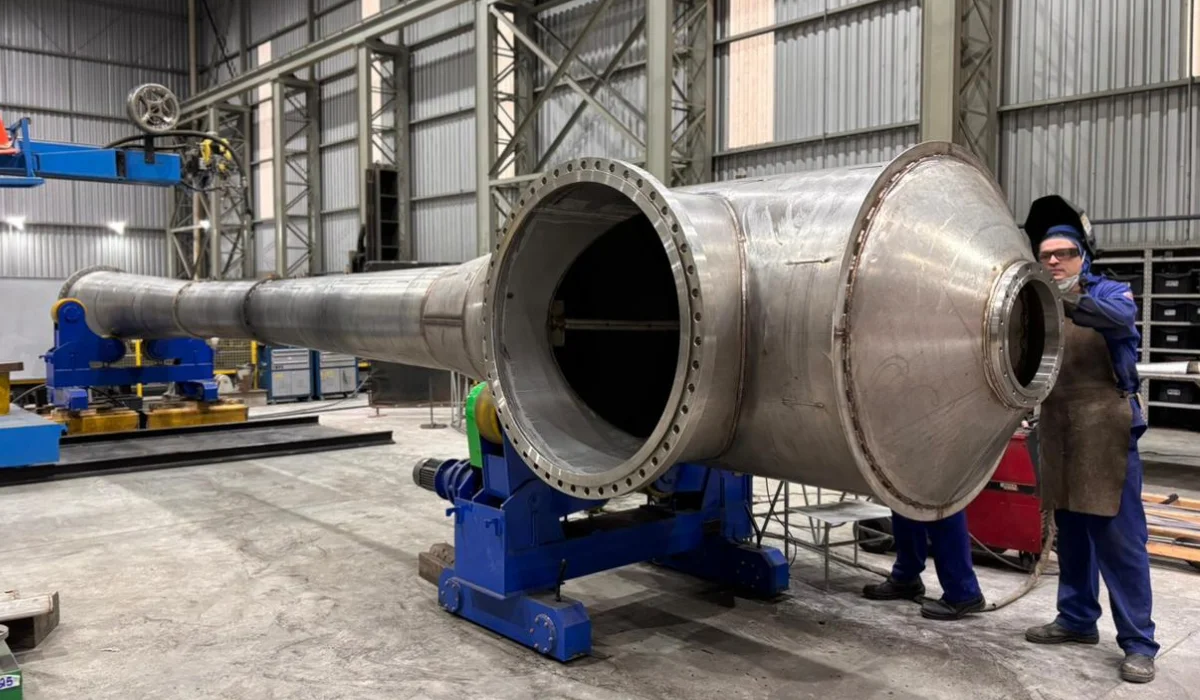 Grande ejetor industrial em fábrica, em construção, com trabalhador usando equipamento de proteção, ilustrando um artigo da Apema sobre ejetores.