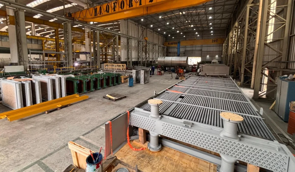 Interior de fábrica com equipamentos industriais e trocador de calor, que ilustra um conteúdo da Apema sobre eficiência térmica.