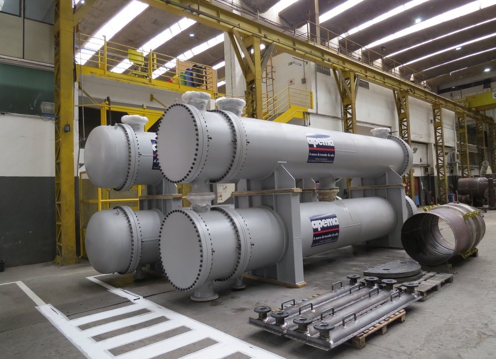 Trocador de Calor Casco e Tubo azul sobre uma mesa branca e fundo de tecido branco.