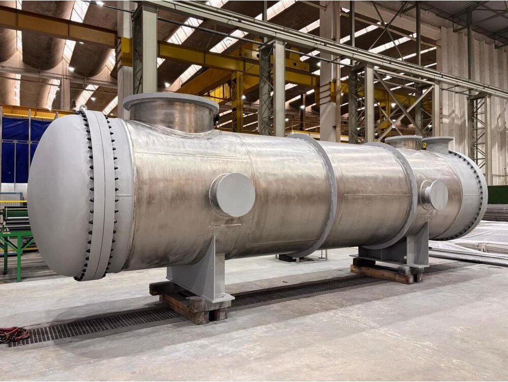 Trocador de Calor Casco e Tubo azul sobre uma mesa branca e fundo de tecido branco.